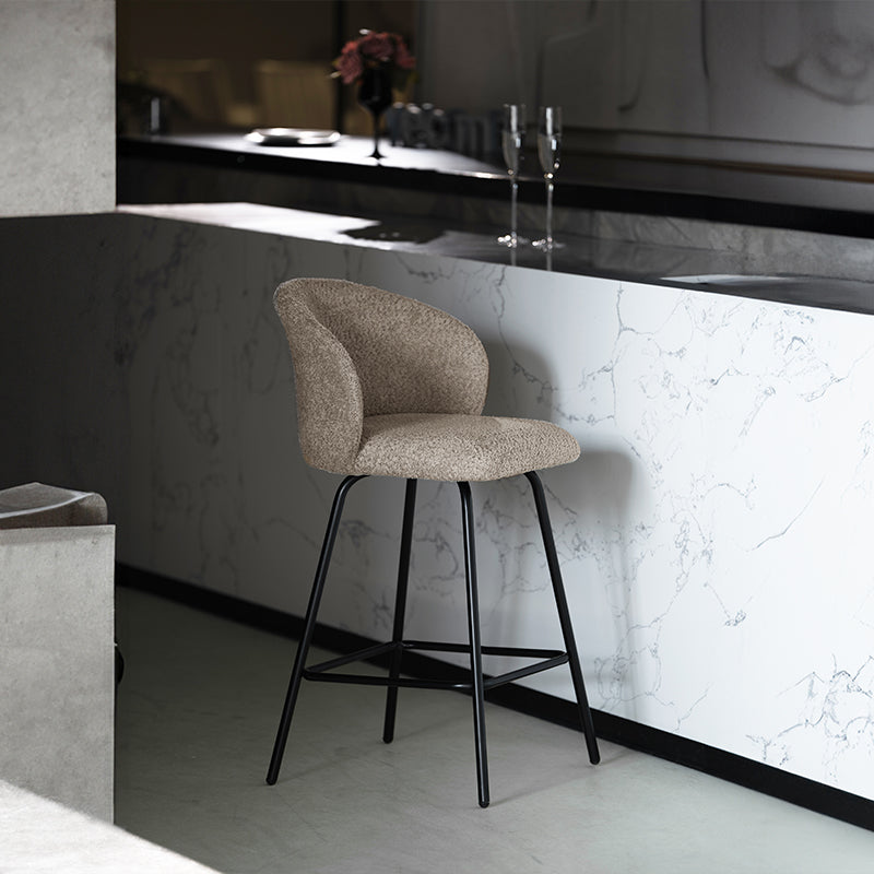 Banqueta giratória Yasin UDC23121 em tecido bouclé, altura 65 cm, perfeita para ilhas de cozinha ou bares. Encosto acolchoado e estrutura em metal resistente.