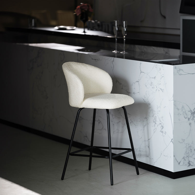 Banqueta giratória Yasin UDC23121 em tecido bouclé, altura 65 cm, perfeita para ilhas de cozinha ou bares. Encosto acolchoado e estrutura em metal resistente.