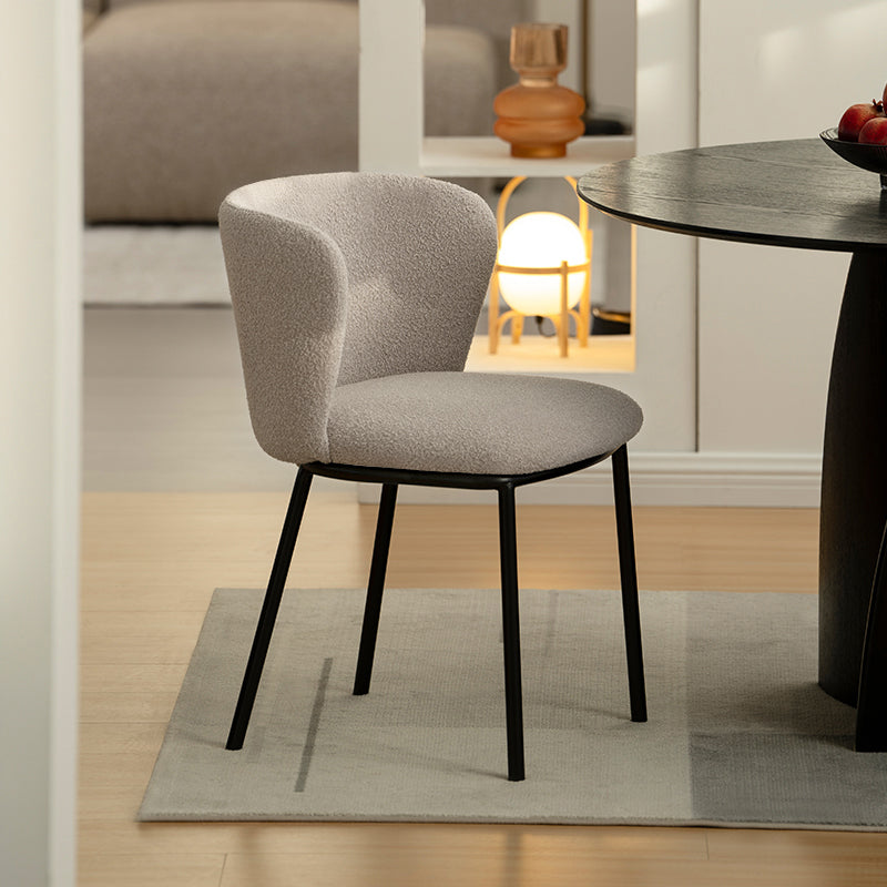 Cadeira de jantar Karin em bouclé bege com encosto alto e pés de metal preto. Perfeita para sala de jantar ou home office. OFCASA.