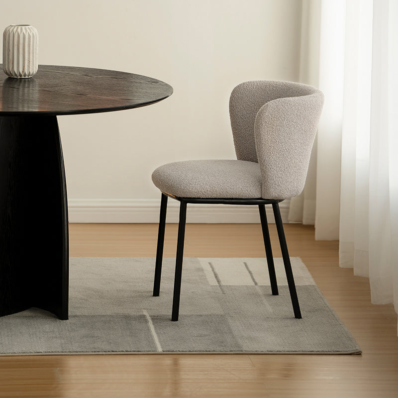 Cadeira de jantar Karin em bouclé bege com encosto alto e pés de metal preto. Perfeita para sala de jantar ou home office. OFCASA.