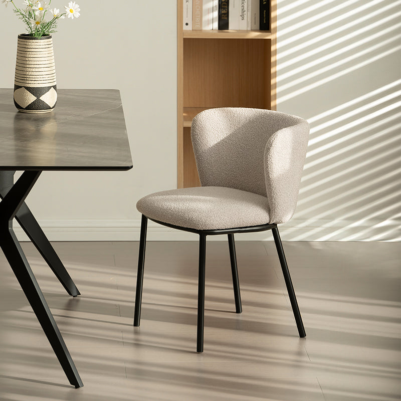 Cadeira de jantar Karin em bouclé bege com encosto alto e pés de metal preto. Perfeita para sala de jantar ou home office. OFCASA.