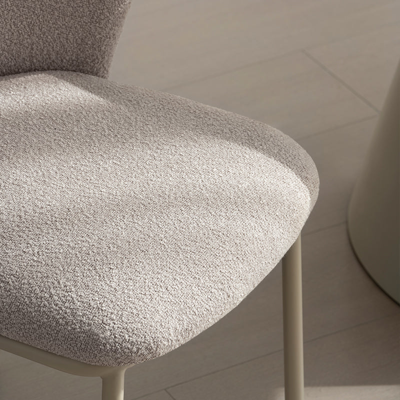 Cadeira de jantar Karin em bouclé bege com encosto alto e pés de metal preto. Perfeita para sala de jantar ou home office. OFCASA.