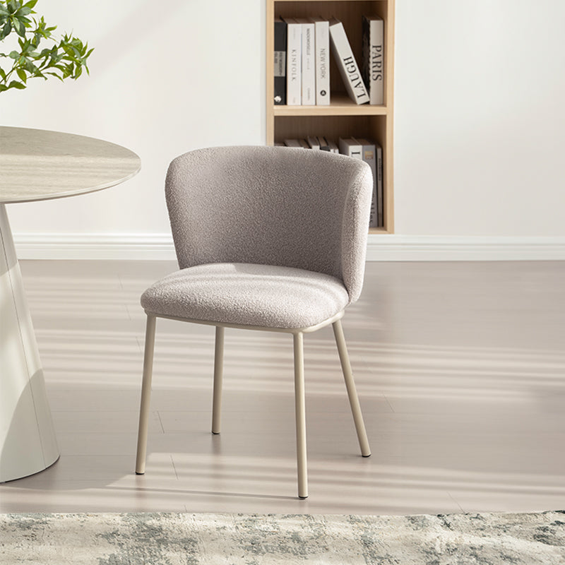 Cadeira de jantar Karin em bouclé bege com encosto alto e pés de metal preto. Perfeita para sala de jantar ou home office. OFCASA.