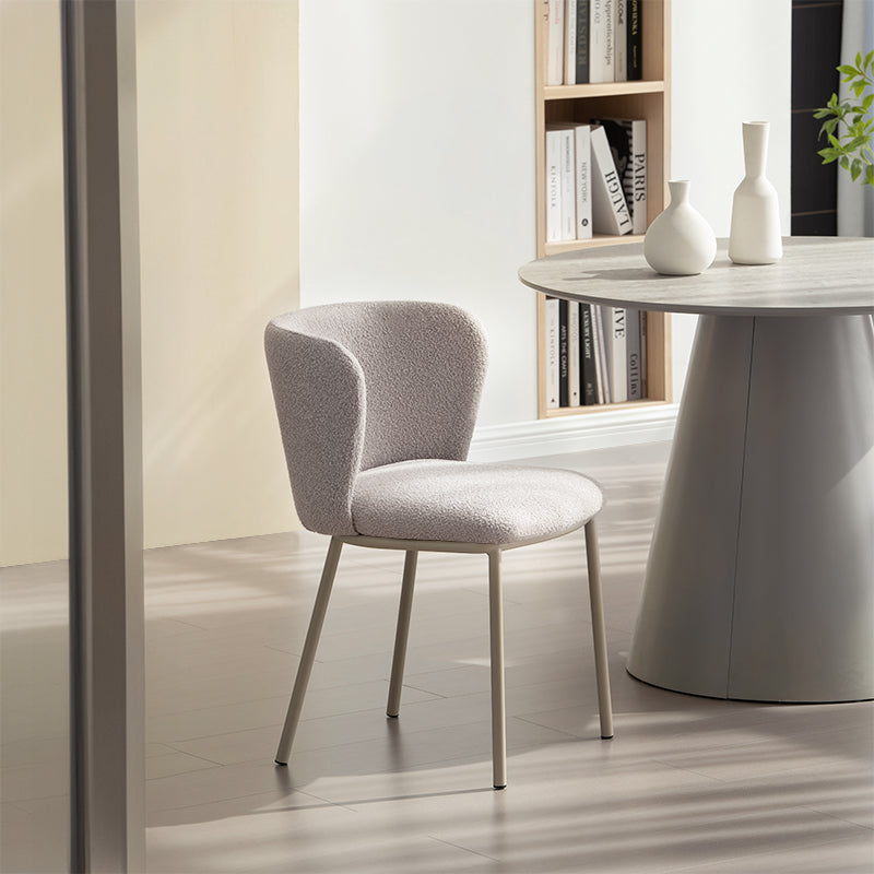 Cadeira de jantar Karin em bouclé bege com encosto alto e pés de metal preto. Perfeita para sala de jantar ou home office. OFCASA.